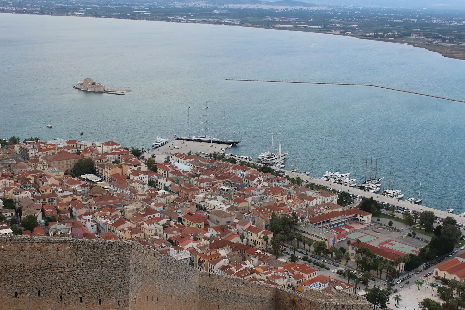 Panoramic view of Nafplio's historic harbor and Bourtzi fortress in the Argolic Gulf.